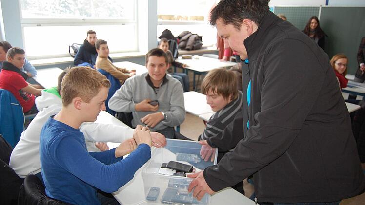 Der herbeigesehnte Augenblick: Thomas Apfel verteilt in der Klasse 8b die eine Woche zuvor eingesammelten Handys. Fotos: Oliver Schmidt
