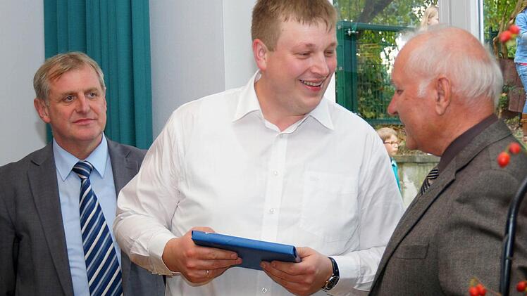 Zapfendorfs Zweiter Bürgermeister Baptist Schütz (rechts) übergibt ein Geschenk. Links hinten: Rattelsdorfs Bürgermeister Bruno Kellner