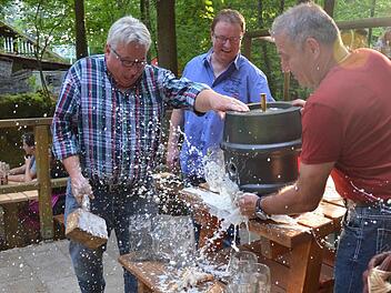 Der überraschte Walther Metzner (links) hatte sich den Fassanstich etwas trockener vorgestellt. Festwirt Wolfgang Römer (Mitte) und Georg Rittmayer (r.) assistieren. Foto: Wilfried Roppelt