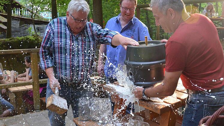 Der überraschte Walther Metzner (links) hatte sich den Fassanstich etwas trockener vorgestellt. Festwirt Wolfgang Römer (Mitte) und Georg Rittmayer (r.) assistieren. Foto: Wilfried Roppelt