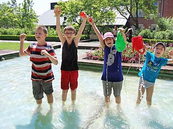 Max, Yannick, Lea und Lukas (von links) genießen die kühle Erfrischung im Kleinen Rosengarten und haben dabei sichtlich jede Menge Spaß. Fotos: Oliver Schmidt