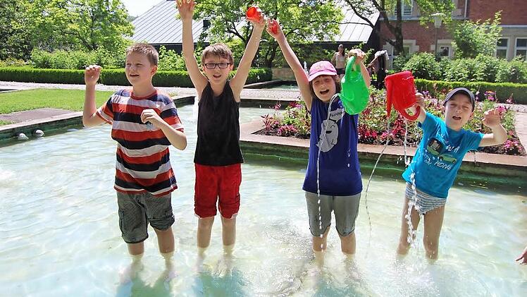 Max, Yannick, Lea und Lukas (von links) genießen die kühle Erfrischung im Kleinen Rosengarten und haben dabei sichtlich jede Menge Spaß. Fotos: Oliver Schmidt