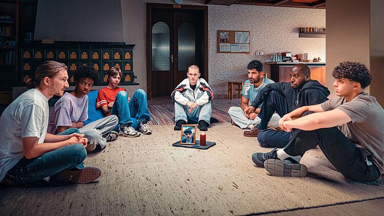 Betreuer und "Klienten" der Wohngruppe haben sich versammelt, um von ihrem toten Mitbewohner und Chef Abschied zu nehmen, von links: Betreuer Simon (Augustin Groz), Oki (Yacouba Diabate), Levi (Christoph Lackner-Zinner), Leon (Tristan Witzel), Betreuer Araz (Emre Cakir), Betreuer Femi (Ayo Aloba) und Mo (Renas Hussin).