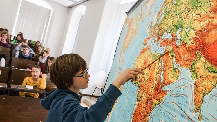 Jonathan zeigt, wo man das Land Syrien auf der Weltkarte findet. Viele Syrer fliehen aus ihrem Land, weil dort ein schlimmer Bürgerkrieg herrscht. Foto: Barbara Herbst