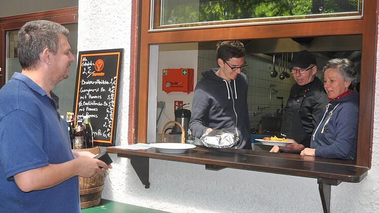 Während Kellerwirt Bruno Alberti eine Essensportion an die Ausreiche bringt, kassieren seine Frau Kristi und Sohn Felix bei Abholer Ulrich Müller ab. Foto: Leo Hühnlein