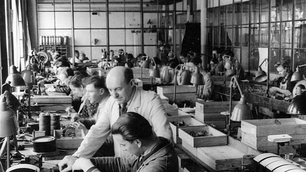 Bis zum Bau von gr&ouml;&szlig;eren  Anlagen  und B&uuml;rokomplexen wurde in Erlangen noch  in  provisorischen  Fertigungsr&auml;umen  (Bild um 1946) produziert. Sie legten in der Nachkriegszeit den Grundstein f&uuml;r den Aufstieg Erlangens zur  "Siemens-Stadt",  aus der der Technologiekonzern nicht mehr wegzudenken ist.   Foto: Siemens Archiv