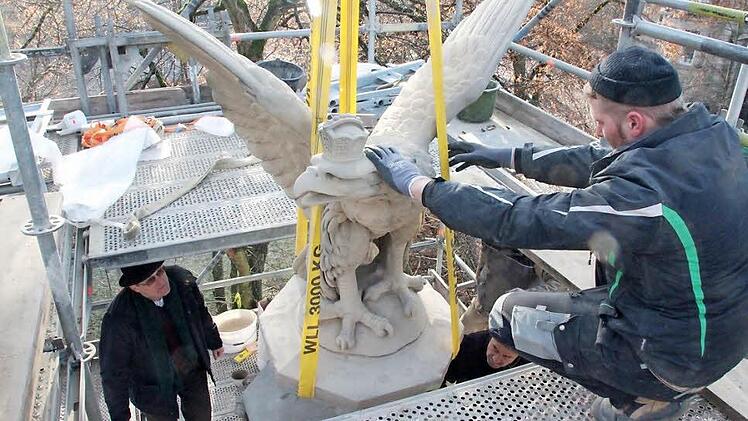 Mit Hilfe eines Krans wurde der restaurierte Adler auf seinen Sockel gehievt. Harald Reißenweber (links), im Bauamt der Stadt zuständig für den Bauunterhalt des Kriegerdenkmals, schaut genau zu. Rechts Christoph Klesse (unten) und Johann Djatlov. Foto: Simone Bastian