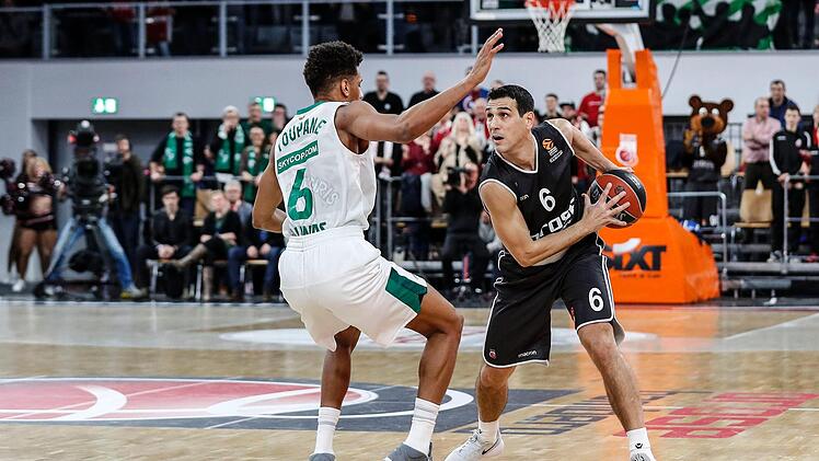 Auch in Bedrängnis - hier gegen Axel Toupane - hat Nikos Zisis (mit Ball) immer den Blick für den freien Mitspieler. In seinen 299 Partien bisher verteilte er 858 Assists und belegt Rang 7 der Euroleague. Foto: D. Löb