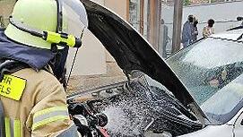 Feuerwehrmann beim Löschen am Fahrzeug