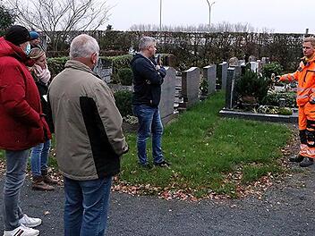 Rasen statt Hecke: Christian Raehse (rechts), Leiter des Bauhofes der Stadt Ebern, zeigt, wie  künftig der gesamte Friedhof zwischen den Grabsteinen aussehen könnte, wenn die  Hecken dazwischen entfernt werden
