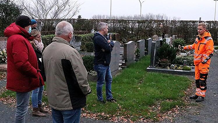 Rasen statt Hecke: Christian Raehse (rechts), Leiter des Bauhofes der Stadt Ebern, zeigt, wie  künftig der gesamte Friedhof zwischen den Grabsteinen aussehen könnte, wenn die  Hecken dazwischen entfernt werden