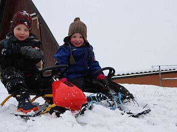 Hurra, der erste Schnee! Annalena (drei) und Matthias (vier Jahre) aus Bramberg können endlich ihre Bobs zum Rodeln ausprobieren.  Foto: Eckehard Kiesewetter