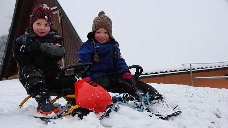 Hurra, der erste Schnee! Annalena (drei) und Matthias (vier Jahre) aus Bramberg können endlich ihre Bobs zum Rodeln ausprobieren.  Foto: Eckehard Kiesewetter