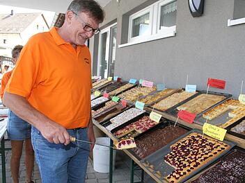 Welche hätten Sie denn gerne? Winfried Hacker häufte den Kuchenfans fast immer mehrere Stücke auf den Teller. Foto: Sonny Adam