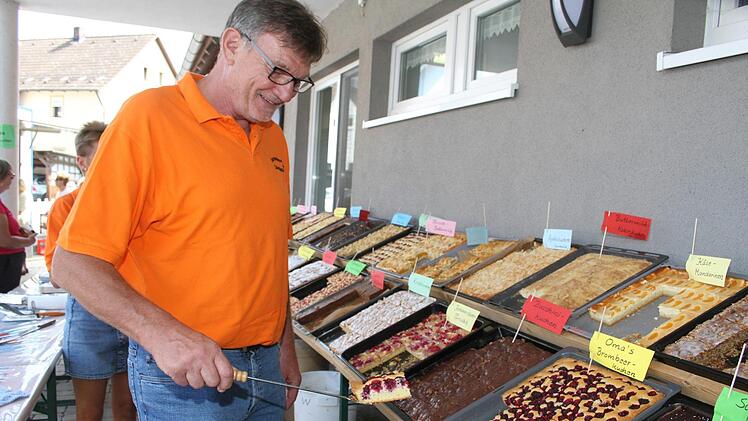 Welche hätten Sie denn gerne? Winfried Hacker häufte den Kuchenfans fast immer mehrere Stücke auf den Teller. Foto: Sonny Adam