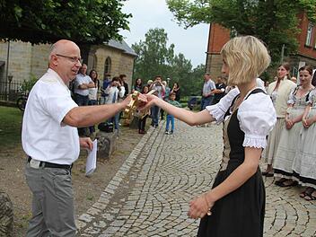 Volker Lauterbach, der Vorsitzende des Förderkreises überreicht den goldenen Lindenschlüssel an Ober-Ortsmadla Marina Ellner. Und die zögert nicht lange und stürmt mit den Ortsburschen die Lindenkrone. Foto: Sonja Adam