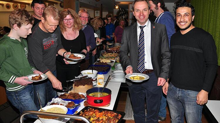 Auch Bürgermeister Matthias Schneider (zweiter von rechts) ließ sich beim "Willkommens-Café" das Essen schmecken, das unter anderem Mohammad Alramadan aus Syrien (rechts) gekocht hatte.