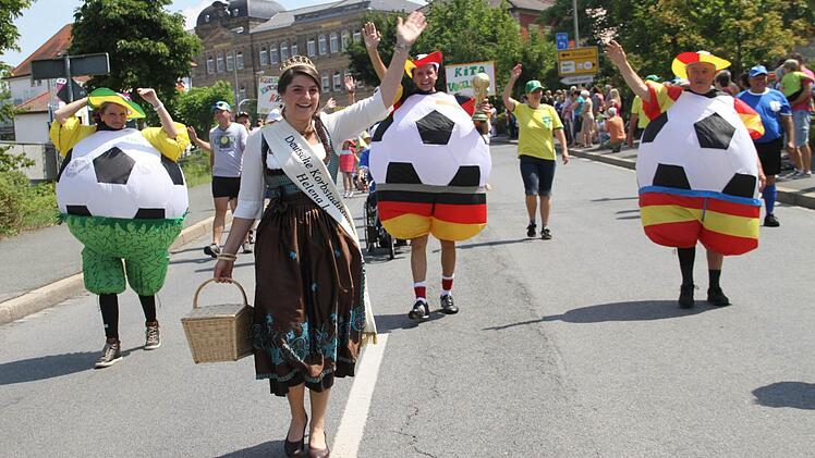Runde Sache: Als riesengroße Fußbälle verkleidet marschierten die drei Bürgermeister der Stadt, Andreas Hügerich (Mitte), Sabine Rießner (l.) und Winfried Weinbeer mit Korbstadtkönigin Helena I. mit.