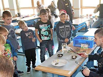 Mit Spannung und voller Aufmerksamkeit verfolgten die Kinder Versuche der Feuerwehr, herauszufinden, welches Material brennbar und welches nicht brennbar ist, hier ist es der Versuch mit einer Nudel. Foto: Karl-Heinz Hofmann