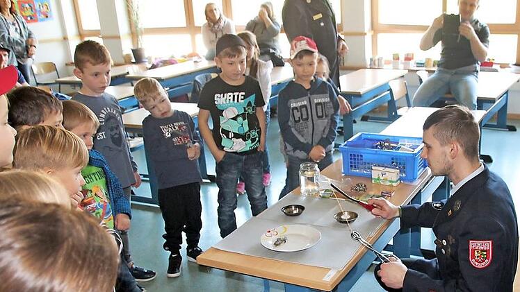 Mit Spannung und voller Aufmerksamkeit verfolgten die Kinder Versuche der Feuerwehr, herauszufinden, welches Material brennbar und welches nicht brennbar ist, hier ist es der Versuch mit einer Nudel. Foto: Karl-Heinz Hofmann