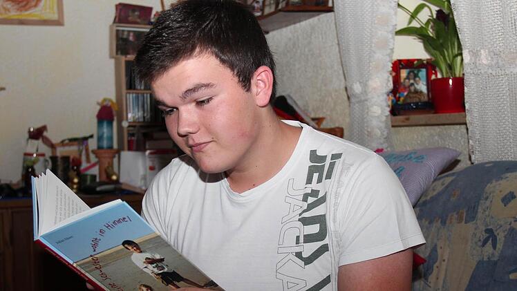 Julian schaut sein Buch an und Erinnerungen werden wach. Foto: Johanna Blum