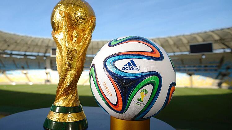 Der WM-Pokal und der offizielle Spielball "Brazuca" warten in Rio de Janeiro auf den Sommer. Foto: dpa/adidas