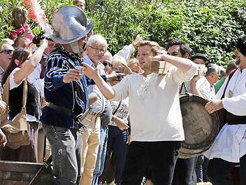 Bei all der Anstrengung hochwillkommen: ein Becher voll Bier. Allerdings müssen die Bräuknechte ihn mit einem Schluck leeren. Viertelmeister Stefan Wicklein, der spätere Sieger, schaut zu (rechts).  Foto: Matthias Hoch