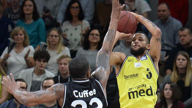 Kassius Robertson beim Dreier-Versuch, links  Michael Cuffee. Foto: Peter Mularczyk