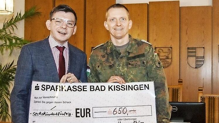 Bürgermeister Warmuth (links) empfängt den Scheck aus den Händen von Oberstabsfeldwebel Münz (rechts).  Foto: Patrik Böhmer