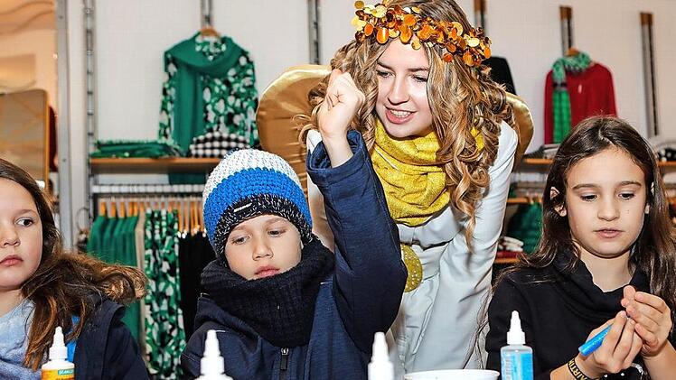 Im Modehaus Schick gestalteten Kinder weihnachtlich verzierte Einkauftaschen. Engel Lena Hofmann half dabei.  Fotos: Matthias Hoch