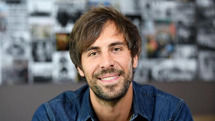 Der Sänger Max Giesinger lächelt am Rande eines Interview-Termins.  Wohnzimmerkonzert statt Livetour: Giesinger und sechs weitere Popmusiker wollen am Sonntagabend per Livestream für ihre Fans spielen. Foto: Britta Pedersen/dpa