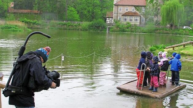 Die Kinder werden bei einer Floßfahrt über den Schlossteich gefilmt. Auch am Kneippbecken wurden Aufnahmen gemacht.  Foto: Norbert Karbach