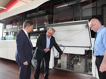 Andreas Hauke (Mitte) zeigt Landrat Alexander Tritthart (links) und Werner Vogel die Steuerungselektronik am Volvo-Hybridbus.  Foto: Andreas Dorsch