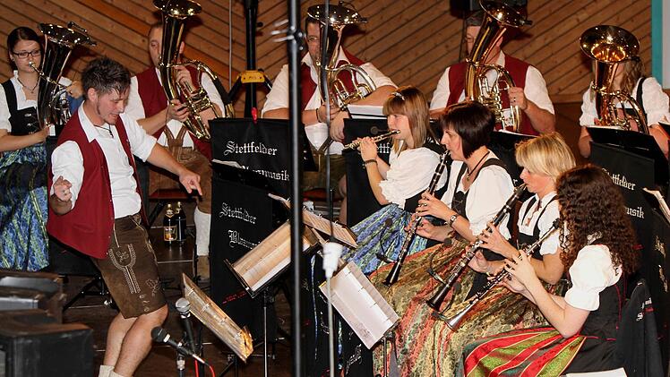 Genauso schwungvoll sieht man immer wieder Dirigent Christian Frank (links), hier vor Flöten und Klarinetten.