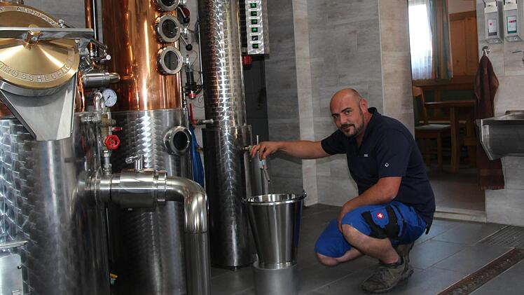 Florian Leicht nimmt eine Alkohol-Stichprobe in seiner Brennerei. Die Teile der Anlage, in denen der Brennvorgang stattfindet, sind aus Kupfer - das sei wichtig für den Geschmack, erklärt der Fachmann. Fotos: Sven Dörr