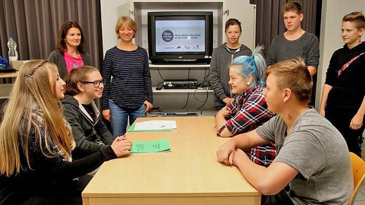 Beim Rollenspiel im Streitgespräch am Tisch (von links) Lena und Julia sowie Zoe und Franz. Hintere Reihe (v. li.) Margarete Schindler und Steffi Mayer (Jugendsozialarbeit) sowie Franz, Moritz und Daniel. Foto: Geiling