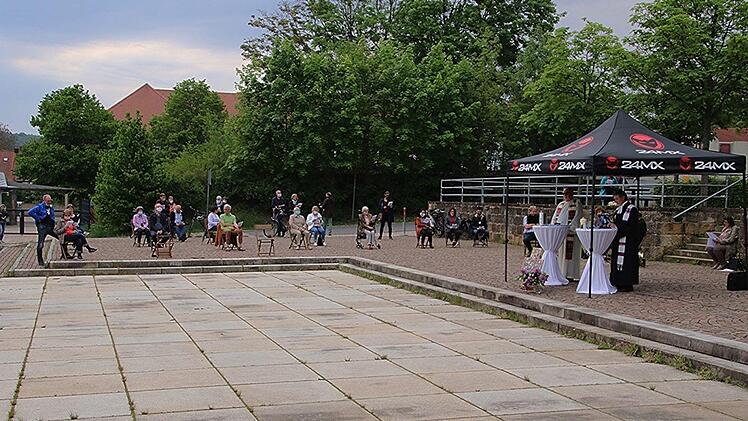 Auch auf der Terrasse oberhalb des Parkplatzes hatten Gläubige in gebührendem Abstand Platz genommen, um den Open-Air-Autogottesdienst bei zu wohnen. Foto: Helmut Will