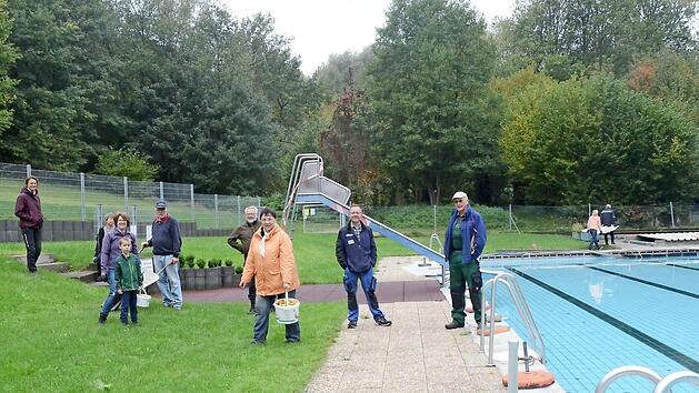 Einige der flei&szlig;igen Helfer, die das Schwimmbad winterfest machten. Dritte B&uuml;rgermeisterin und Kassiererin Ruth T&ouml;lg (mit Eimer) tr&auml;gt gerade frisch geerntete Tomaten weg, die man entlang des Schutzzaunes pfl&uuml;ckte.  Foto: K.- H. Hofmann
