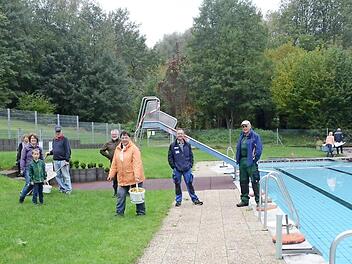 Einige der fleißigen Helfer, die das Schwimmbad winterfest machten. Dritte Bürgermeisterin und Kassiererin Ruth Tölg (mit Eimer) trägt gerade frisch geerntete Tomaten weg, die man entlang des Schutzzaunes pflückte.  Foto: K.- H. Hofmann