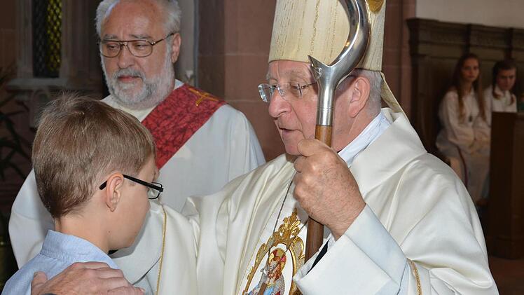 Weihbischof Ulrich Boom spendete Benjamin Beck aus Windheim sowie 43 weiteren Firmlingen in der Pfarrkirche St. Trinitas in Aschach das Sakrament der Firmung. Im Hintergrund Diakon Franz Hey.  Foto: B. Hein