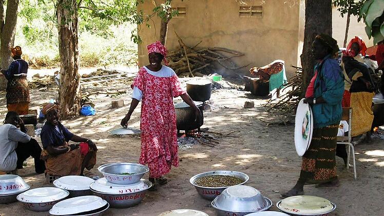 Gekocht wird in Senegal von vielen Menschen am Boden.