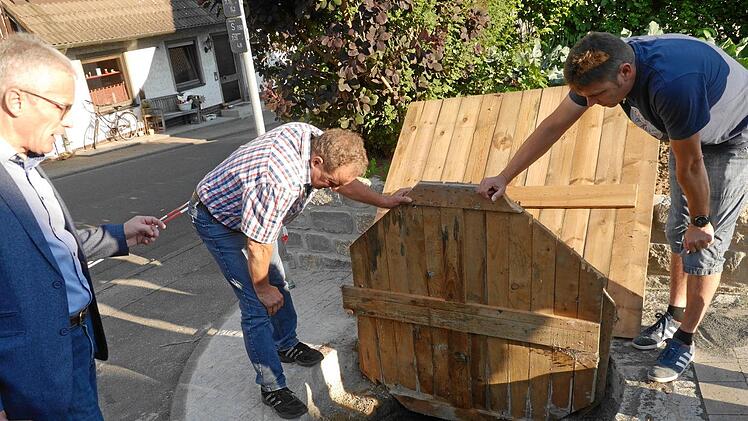 So gestaltet sich bisher der Ausbau des Brunnens in der Rapsgasse - mit provisorischer doppelter Abdeckung aus Holz. Jetzt soll dort ein Schmuckstück entstehen. Bürgermeister Günter Pfeiffer (links) nimmt das Werk in Augenschein.Klemens Albert