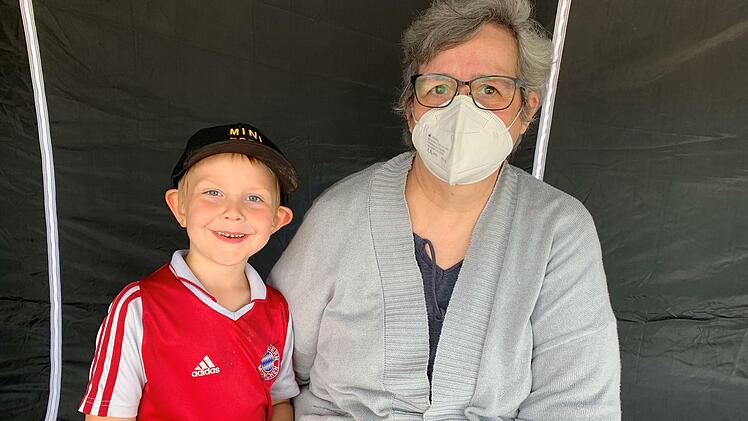 Sonja Vance sitzt während der vorgeschriebenen 15 Minuten Ruhezeit im Zelt, begleitet wurde sie von ihrem Enkel Mason. Foto: Landkreis Bad Kissingen/Vorndran