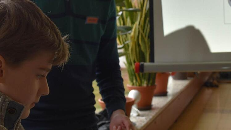 Alexander Schubert erwärmt unter der Anleitung von Moritz Polz die Metallkugel und stellt fest, dass sich die Kugel unter der Hitze größer wird. Foto: Gabi Arnold