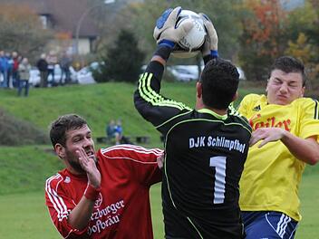 Sichere Beute: Schlimpfhofs Torwart Sebastian Schübert fängt den Ball vor Philipp Klug (rechts) von der SG Oberleichtersbach/Modlos. DJKler Sebastian Schreck (links) braucht nicht eingreifen. Foto: ssp