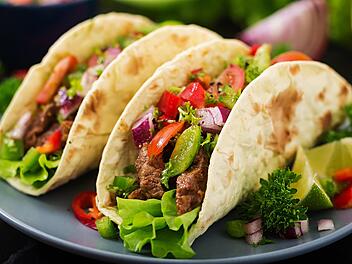 Drei leckere, bunte Tacos auf einem Teller, gef&uuml;llt mit Gem&uuml;se und Fleisch. Ideal f&uuml;r das neue mexikanische Soulfood-Restaurant in Bamberg.