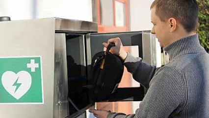 Tim Pistor demonstriert, wie der Defibrillator nach dem Notruf entnommen werden kann. Foto: Katharina Müller-Sanke