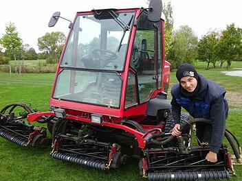 Dominik Anding am Semirough-Mäher: Mit dieser Maschine kann er auf einer Breite von 3,80 Meter das Gras kurz halten. Foto: Anton Then