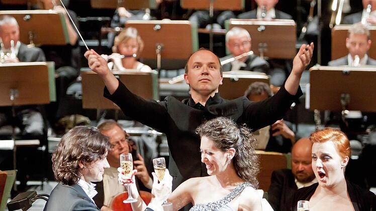 Generalmusikdirektor Roland Kluttig dirigiert beim Trinklied aus Verdis "La Traviata" nicht nur Chor, Solisten und Orchester, sondern auch das eifrig mitklatschende Publikum.