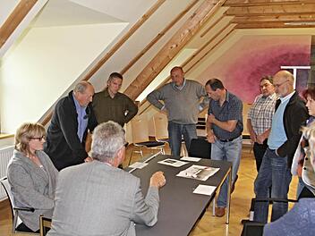 Bürgermeister Helmut Dietz (Rücken zum Bild) erörtert mit seinem Gemeinderat (von links) Sandra Schramm, Gerhard Roth, Robert Bohla, Jürgen Fromm, Gerald Karl, Dieter Reisenweber, 2. Bürgermeister Siegfried Kirchner und Birgit Finzel das Für und Wider der angebotenen Tische und Stühle. Foto: Helmut Will
